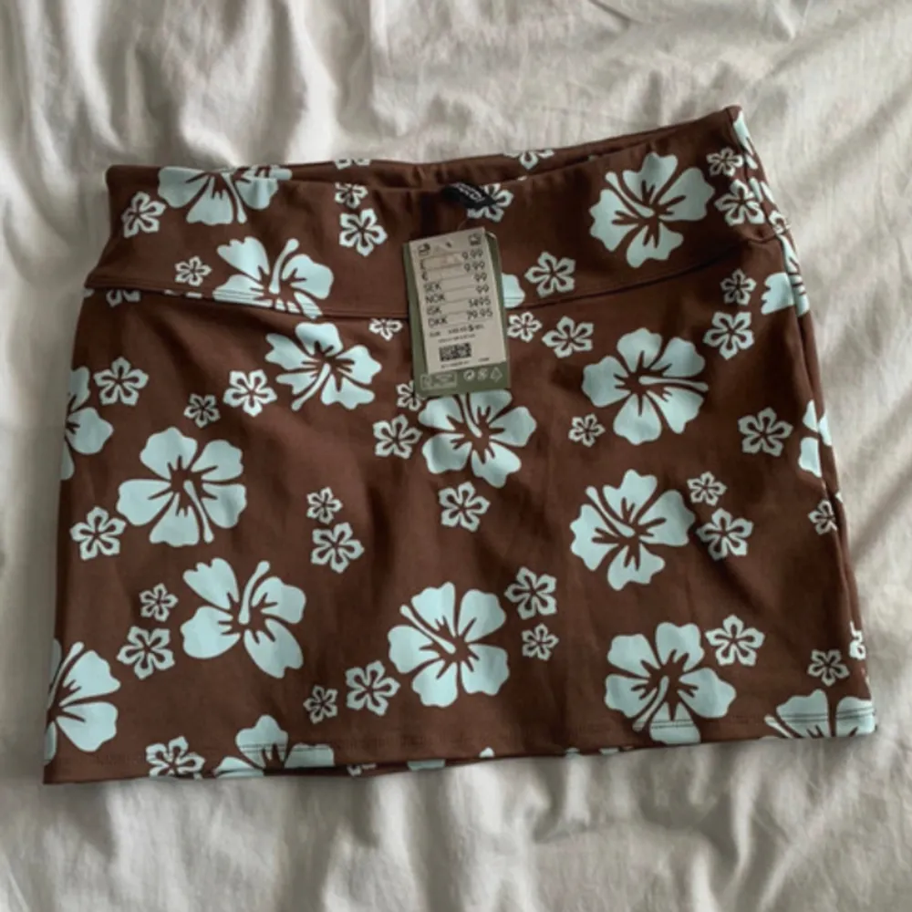 Brun miniskirt med blommor på från H&M. Aldrig använd och har prislapp kvar. Perfekt till sommaren🫶. Kjolar.