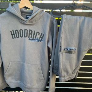 Hoodrich set - Ett helt nytt ställ (hoodie & byxa) från Hoodrich i mörkgrått!  Oanvänt och nyskick då min son ”bytte stil” och inte kommer använda det. Inköpt i butik, nypris ca 2000 kr. Hoodie: Juniorstorlek XL (14-15 år). Byxa: Juniorstorlek L (12-13 år). 