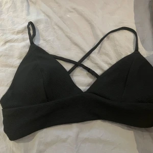 Bikiniöverdel  - En fin bikiniöverdel från h&m som är korsad bak i ryggen. Jag säljer denna då jag bara använt den en gång, den är även i bra skick. Denna bikiniöverdelen skulle passa den som har lite större bröst, mellan C/D kupa. 