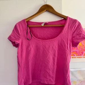 Rosa kortärmad topp från H&M - En rosa kortärmad topp från H&M Basic. Toppen har en rund halsringning och är tillverkad i ett mjukt material. Ett märke upptill från en klädnypa men går säkert bort i en tvätt och strykning. Ancänd några gånger .