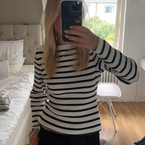Stickad tröja  - Randig stickad tröja från Lindex som aldrig är använd. Guldiga knappar vid axlarna! 