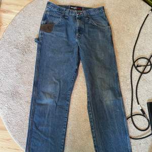 Wrangler vintage workwear / carpenter jeans i stl 31x32 tum (midja X ben) sitter lite för stort på mig, (180cm 58kg mans kropp) men byxorna är riktigt snygga och av högkvalitativt tjockt denim.  Skickas med postnord eller hämtas i lund