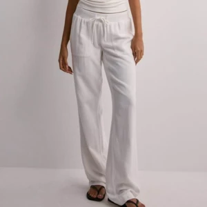 Lågmidjade linnebyxor - Vita Low Waist Linen Pants från Nelly i storlek Medium. Dom är lågmidjade och är raka i modellen. Materialet är tjockt och inte genomskinligt. Aldrig använda. Nypris är 499kr men säljer för 299kr.🩷🩷
