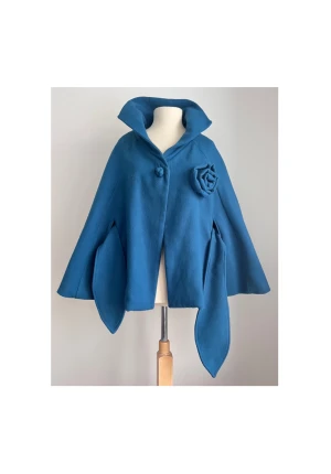 A-line formad cape/poncho med blomdetalj - Märke: Vintage (lappar saknas). Storlek: Onesize. Skick: Mycket gott. Endast använd ett fåtal gånger. Pris: Bud från 450:-. Frakt: Betalas av köparen.