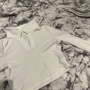 Vit topp - Säljer en super söt, tunn, vit topp med krage från shein i stl. S. Aldrig använd (men har ett litet märke, bild 2, pga stället den legat på, men går att få bort)och säljer för 50kr+frakt. (Kan i vissa fall mötas upp)😊