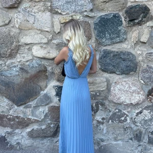 Balklänning  - En fin ljusblå balklänning i storlek 34, använd en kväll. Går ner nästan ner till fötterna på mig som är 175. Är en liten söm nertill som ”fnasat” upp sig lite men går att fixa med nått stygn. Sen en liten fläck som va där innan jag använt den. 