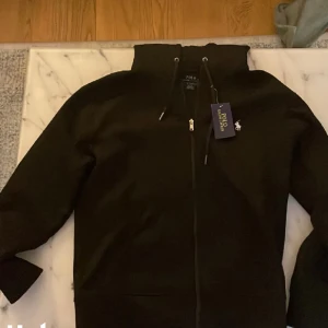 Svart Ralph lauren zip hoodie - Mycket bra skick, köptes för julklappspengarna men alldeles för liten i storleken. Inga skavanker Nypris:2100 Mitt pris:650 (priset kan diskuteras)