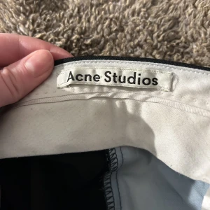 Kostymbyxor  - Snygga kostymbyxor från acne studieos i storlek 34. De har en slits ner ner som tyvärr är klippt med sax, kan skicka bild på det vid intresse. Annars i fint skick, tecken på användning finns dock :) 