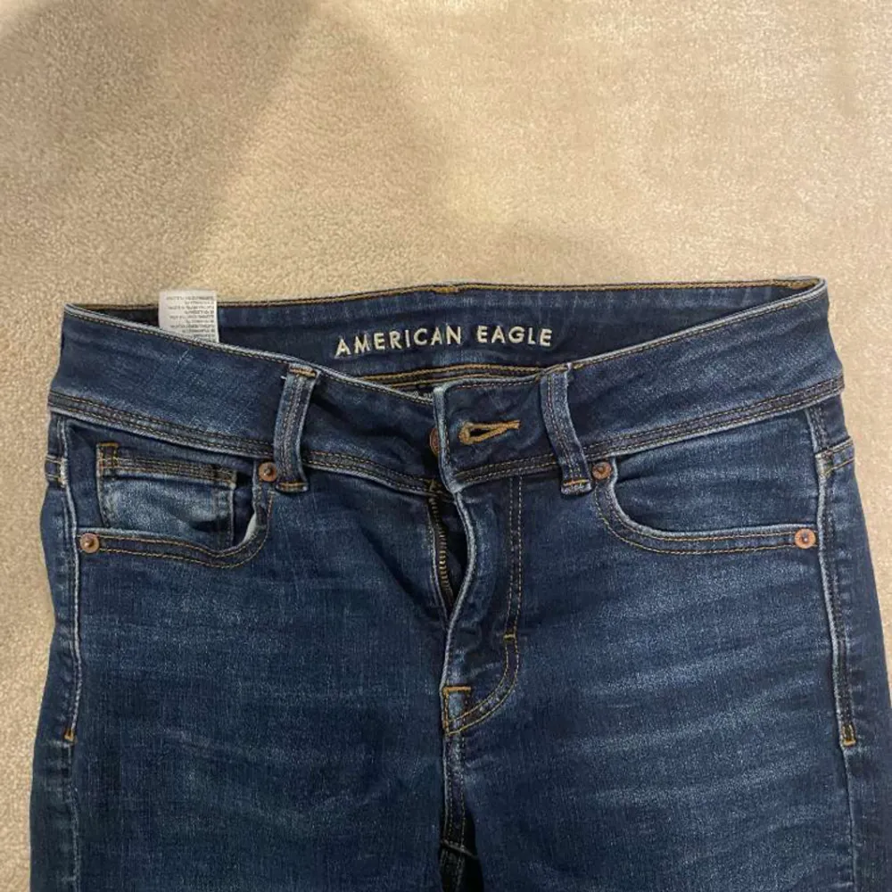 Snygga mörkblå jeans från American Eagle med coola fickor! Innerbenslängd:72 midjemått:38💕 Skriv för mer info!💕. Jeans & Byxor.