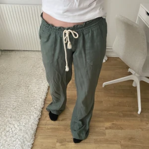 Lågmidjade Tygbyxor Roxy - Använd några fåtal gånger, skrynkliga på bilden men annars i mycket bra skick!  Modellen är 165 cm, men de passar även mig som är 177 cm  Nypriset är: 650 kr 