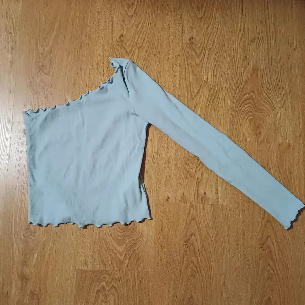 Ljusblå ribbad tröja med en ärm(vänster), använd ett fåtal gånger, mycket fint skick. Tröjor & Koftor.