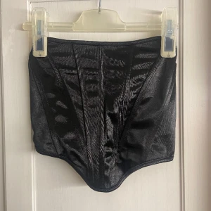 Oanvänd korsett storlek xs  - Säljer denna oanvända korsetten i storlek Xs/34 Superfint glansigt svart tyg och den sitter perfekt