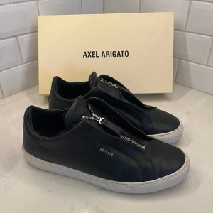 Axel Arigato Zip - Ett par arigatos zip i riktigt bra skick! Finns ej att köpa längre men nypris är 2500 och orginal bag ingår. Priset är diskuterbart vid smidig affär😊