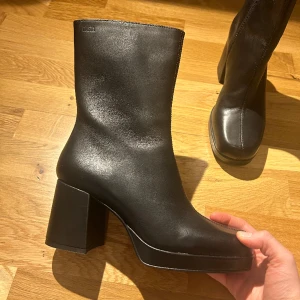 Svarta boots med tjock klack - Helt oanvända boots/klackar i äkta läder som köptes i november 2022. I nyskick då de aldrig använts utomhus. Svart skokräm skickas med då de är obehandlade. Pris kan diskuteras. Nypris 1600kr