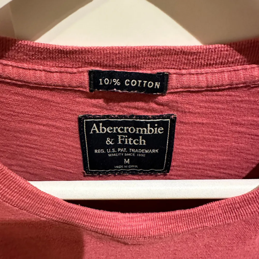 Här presenteras en ljusröd T-shirt från Abercrombie & Fitch. Tillverkad av 100% bomull med en baggy passform. Väldigt bra skick pga dess oanvändning.. T-shirts.