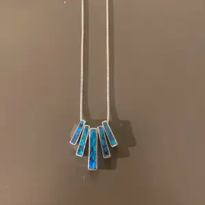 Halsband med silverkefja och blå stenar