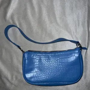 En ljusblå handväska från H&M, använd 1 gång. 