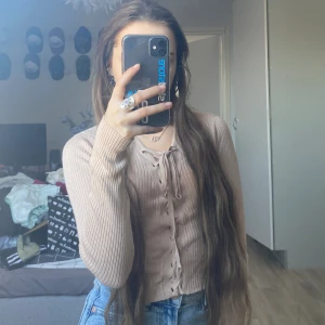 Beige tröja - En beige tröja med snören framtill