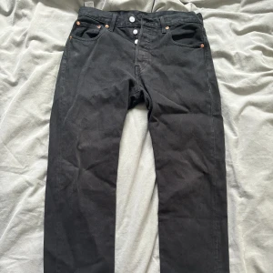 Svarta Levi jeans - Litet hål på låret