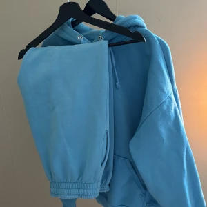 Blå hoodie och mjukisbyxa - Blå hoodie och mjukisbyxa säljs som ett set. Båda i storlek M. I gott skick. Från bikbok