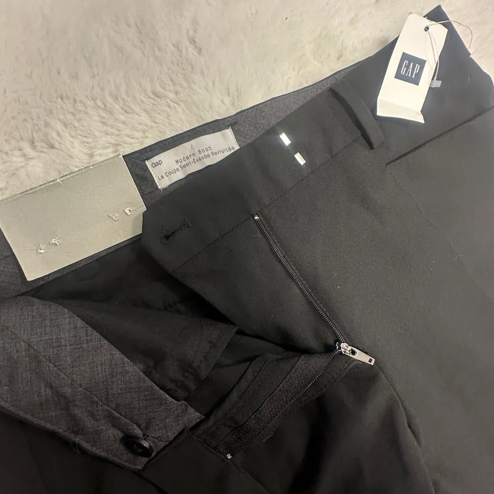 Säljer ett par nya Lågmidjade svarta kostymbyxor från märket GAP. De faller väldigt fint på benen! Storleken på ettiketten år eu 32, men de är också som 34. Midjemåttet är 38 och innerbenslängden är 83. ifall man vill sprätta upp finns 5cm + 💕. Jeans & Byxor.