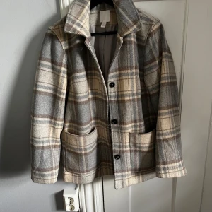 Rutig höstjacka - En medellång höstjacka från H&M i fint skick. Bältet som är till finns inte kvar.