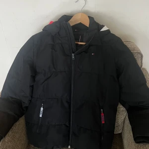 Vinterjacka - Vinterjacka från Tommy Hilfiger!! Jättefin jacka för pojkar. Jackan är även vattenavvisande och fickorna fodrade. Luvan är avtagbar. Använd ett fåtal gånger och säljs pga att den är för liten nu. Jackan är i mycket god skick!! 🤌 Nypris: 1395 kr