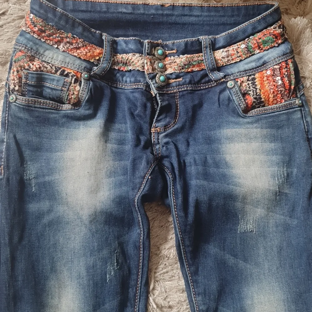 Jeans som är ovanliga  med massa detaljer..massa paljetter både fram och bak snygga knappar låg midjande ..fickor fram bak snygga slitningar storlek 26 passar xs s väldigt fint skick!. Jeans & Byxor.