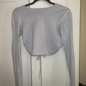 Tröja med öppen rygg - Använd 1 gång.  Går till naveln ungefär. Ljusblå  Passar xs/s