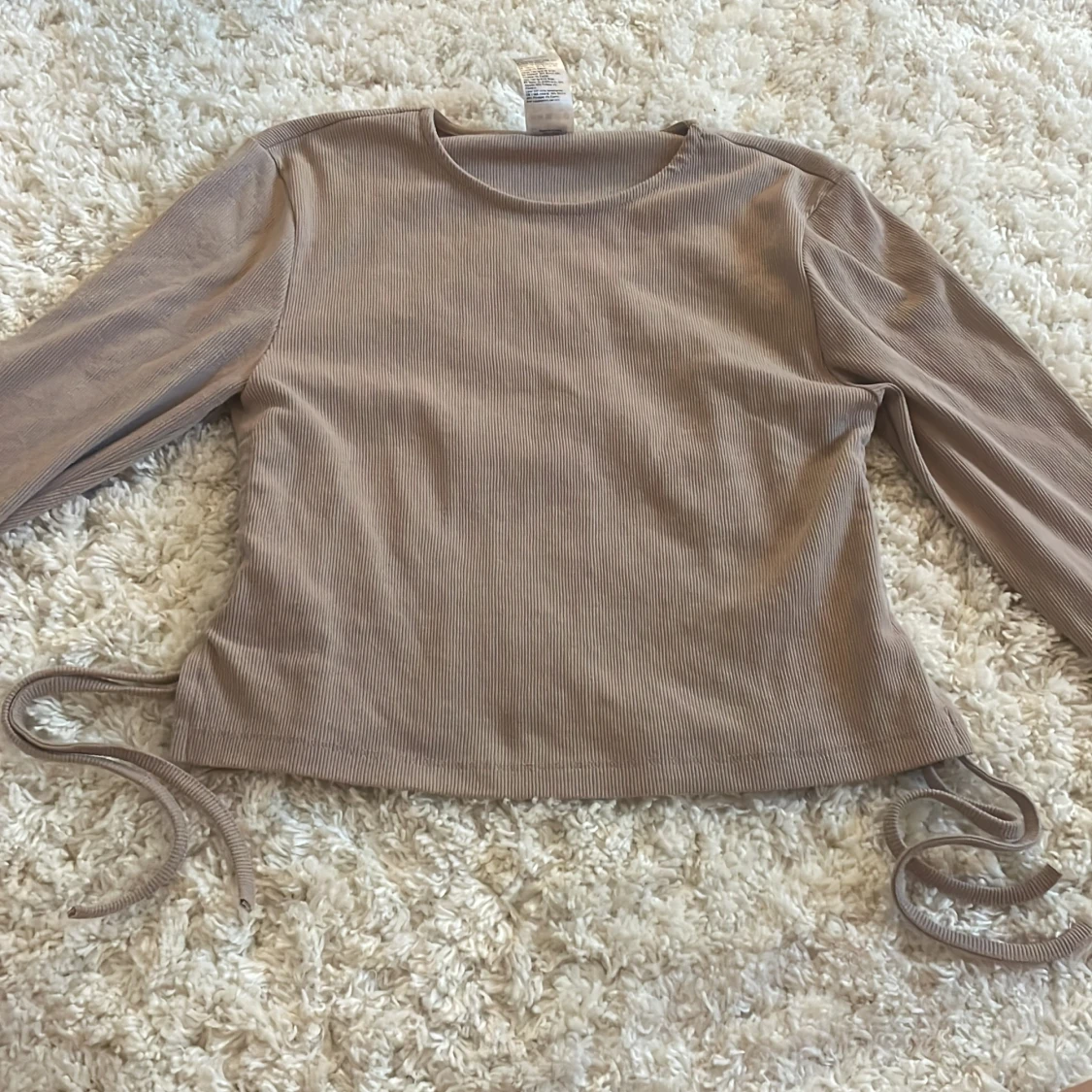 Beige tröja med slits och snören längst ner