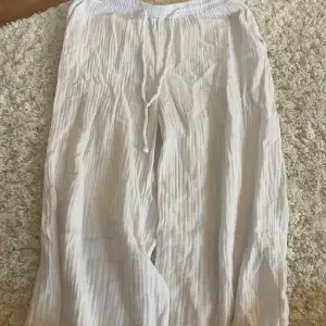 Långa linne vita byxor som endast är skrynkliga, inga andra skador