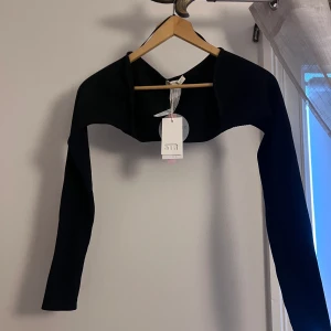 Svart shrug ✨ - Aldrig använd, helt nytt skick 😍 Perfekt till linnen och strapless toppar 💕 Storlek: S, känns lite mindre i storleken ✨ Säljer pga förliten i storleken ☀️ Är ribbat tyg 🥰