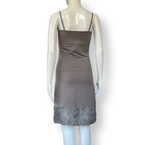 Klänning  - En klänning från Kaffe, storlek S. Dockan använder XS. Stretchig material! 95% bomull & 5% elastan. Silver/grå färg? MÅTT: Armhåla till armhåla 38cm, midjebredd 35cm & längd (mätt från armhåla och ner) 77cm 