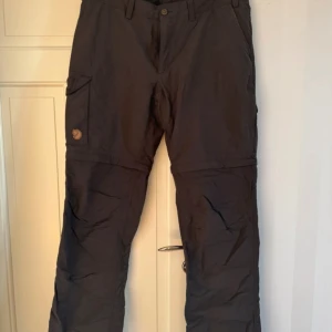 Fjällräven byxor - Fjällräven outdoor byxor. Storlek 42. Inga anmärkningar.   Mått Innerben 86 cm Ytterben 108 cm Lår vid shortsens dragkedja 52 cm Midja 84