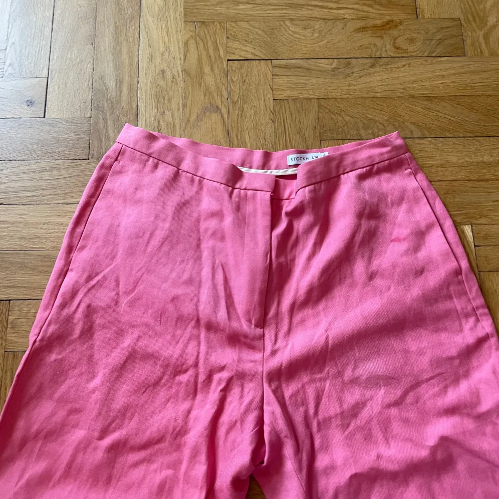 rosa linnebyxor från Stockholm Lm.  Slitsar, väldigt lång modell. Smutsig i nedre kanten. Något noppig däruppe i bak. Sparsamt använda i övrigt. Jeans & Byxor.