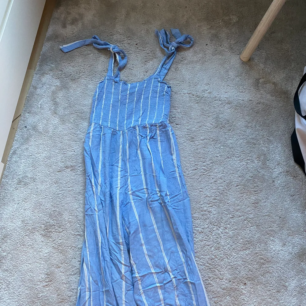 En fin jumpsuit som passar perfekt till sommaren. Banden går att knyta så de är justerbara . Klänningar.