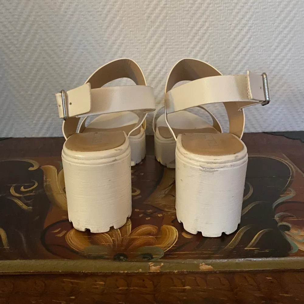 Vita sandaler med klack köpta från Scorett. Två små repor på vänster sko, se bild 2.. Skor.