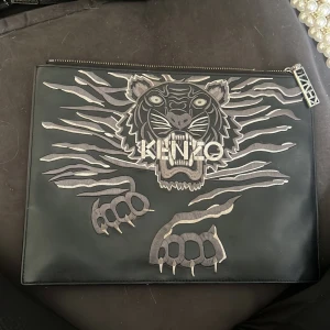 Kenzo clutch - Riktigt skinn, har någon litet fläck på baksidan som säkert går bort om man gör rent den. 