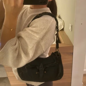 Axelremsväska - Svart axelremsväska i läder med nitar tunga på bandet och ormskinns imitation från märket Caterina Lucchi. Matierialet på utsidan känns lite slitet och släljs därför billigt 💗💗