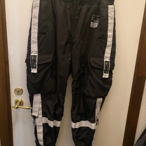 Cargo byxor från New Yoker  - Ganska andvänd men fortfarande i bra skick. Fickorna på sonen har dragkedja runt hela så man kan öppna ut hela har även band vid midjan . Ganska små i modellen.