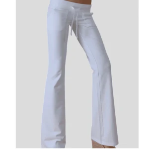 Lågmidjade utsvängda byxor - Lågmidjade utsvänga byxor med fickor. Aldrig använda. Nypris 899kr. Innebenslängden är 74cm  och midjan rätt över är 37cm. Snörning i mindjan så kan nog passa XS också