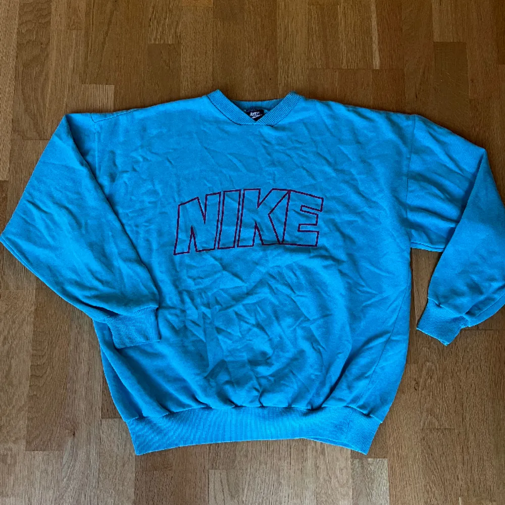 Vintage Nike tröja, i fint vintage skick = mindre defekter finns, men inget märkbart! Svårt att få med färgen på bild men den är ljusblå med rosa tryck! :). Tröjor & Koftor.