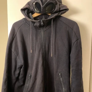 CP Company Hoodie - CP Company Goggle Hoodie, Strl M. Köpt på NK. Nypris 2799kr. Fler bilder kan fixas. Hör av dig vid frågor. Kan tänka mig byta också. Pris kan diskuteras. Tags/Kvitto medkommer ej. Fler fotton kan också fixas. 