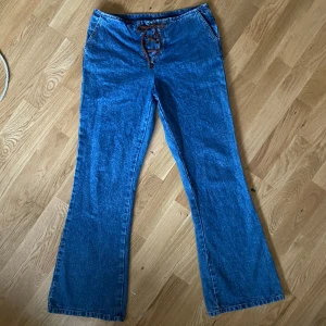 Retro utsvängda jeans med snörning y2k - Snygga jeans med snörning från början av 2000 talet. Fint skick, se bilder för egen bedömning! Passar mig som har s-m i byxor. Mått: Midja-78 cm, Stuss(över rumpan)-100 cm, innerbenslängd-79 cm. Kan mötas upp i centrala stockholm💞