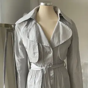 Trenchcoat från Vero Moda Designes Choice  Köpt i Köpenhamn  Färgen är grå/silver med lite glans 
