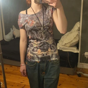 Cool t-shirt med rinestoness  - Tröjan är polygester så de e tunt matrial men den är super fin med coola tryck och rinestones 