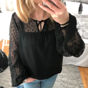 En svart blus från vila  - En nästintill oanvänd blus från vila i svart med en söt rosett! Skriv om du har några funderingar:)