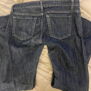 Lågmidjade bootcut jeans - Lågmidjade bootcut jeans från Lee i mörkblå. Har diamanter på flickorna men några har ramlat av. 