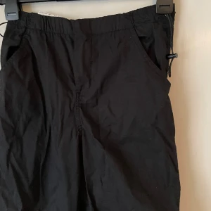 Parachute-byxor från Pull&Bear - Svarta parachute-byxor från Pull&Bear, aldrig använda. Storlek S. Säljer för 150:-. Köparen betalar ev frakt. 