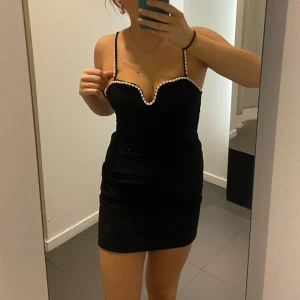 Miniklänning  - Superfin svart miniklänning med pärlor, helt oanvänd med prislapp kvar!